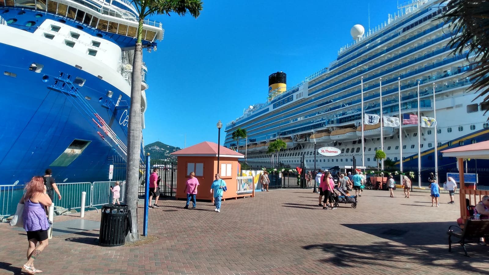 Des visiteurs entre des paquebots et les guérites orange du terminal de Crown Bay, à St. Thomas.